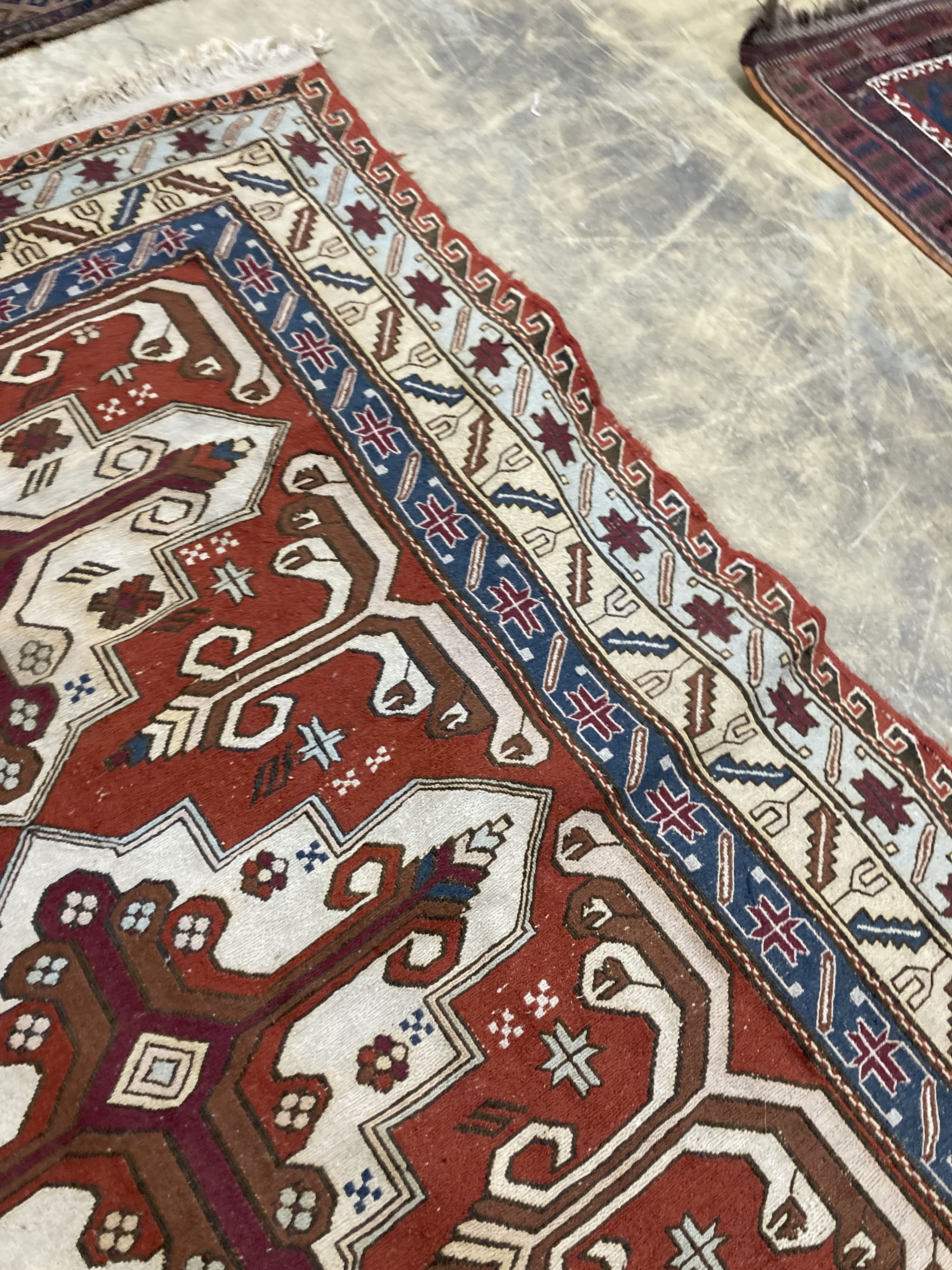 A Caucasian design red ground rug, 240 x 165 cms.